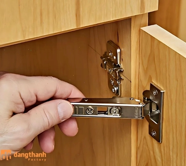 Dùng tay tháo bản lề bật để lắp vào cánh tủ