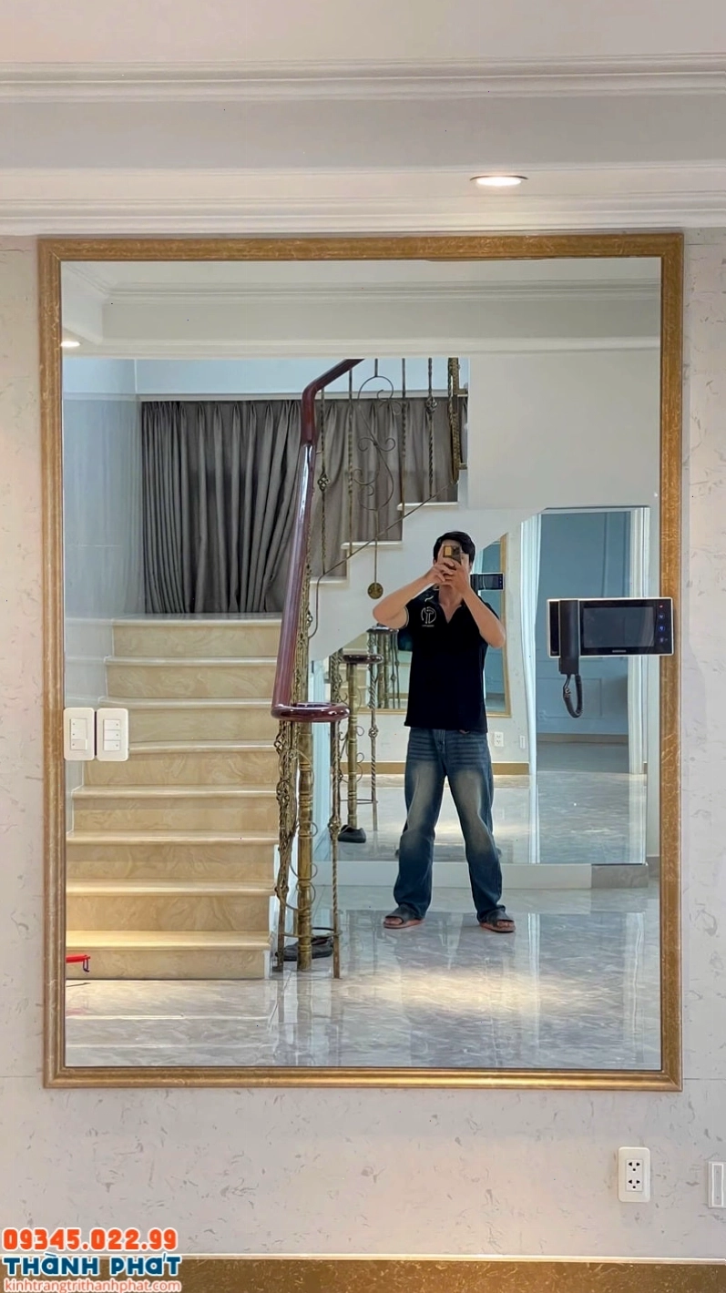 Gương khung vàng sang trọng đặt cạnh khu vực bàn ăn