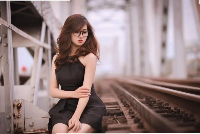 Cô gái ngồi trên ban công, nhìn ra khung cảnh thành phố về đêm