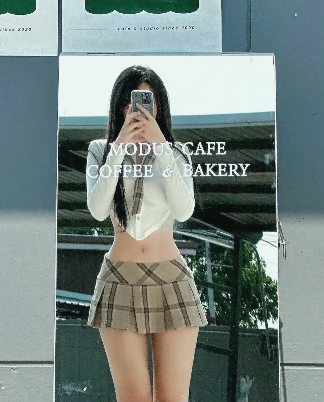 Cô gái tóc đen diện váy ngắn ngoài bãi biển, nở nụ cười nhẹ nhàng