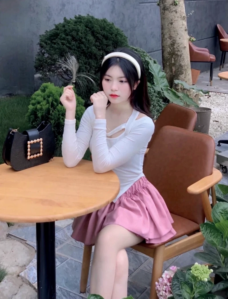 Cô gái tóc ngắn mặc áo len kem giữa nắng phố buổi sáng